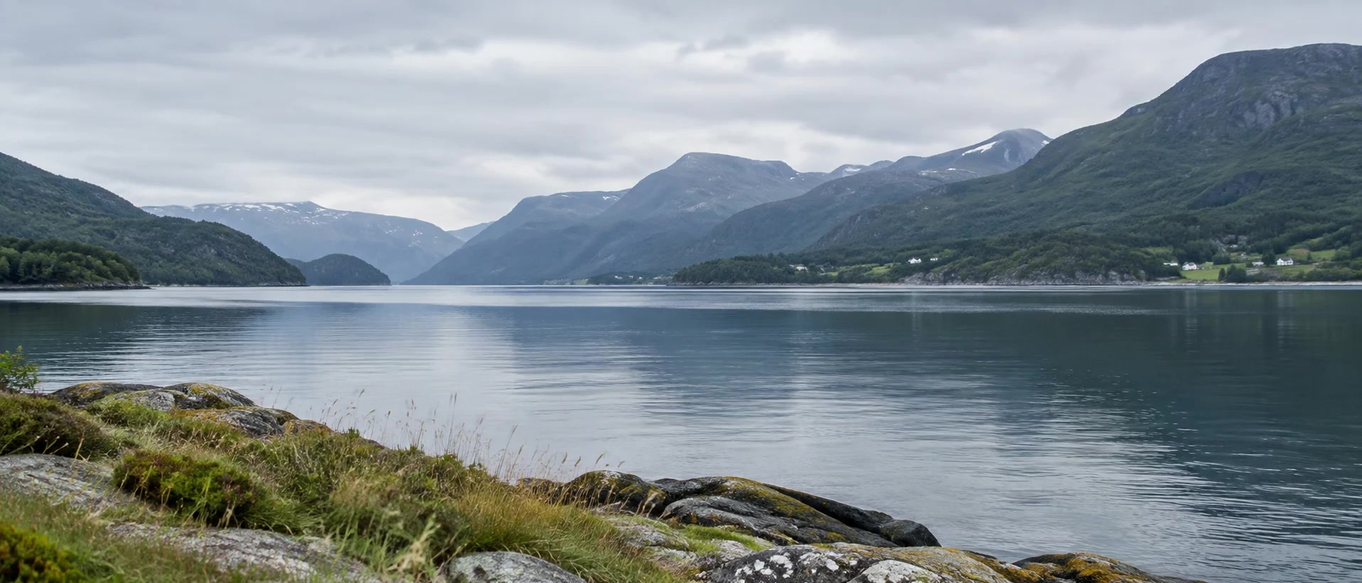 Naturlige krusninger i fjorden, med fjell og strandlinje i ro.
